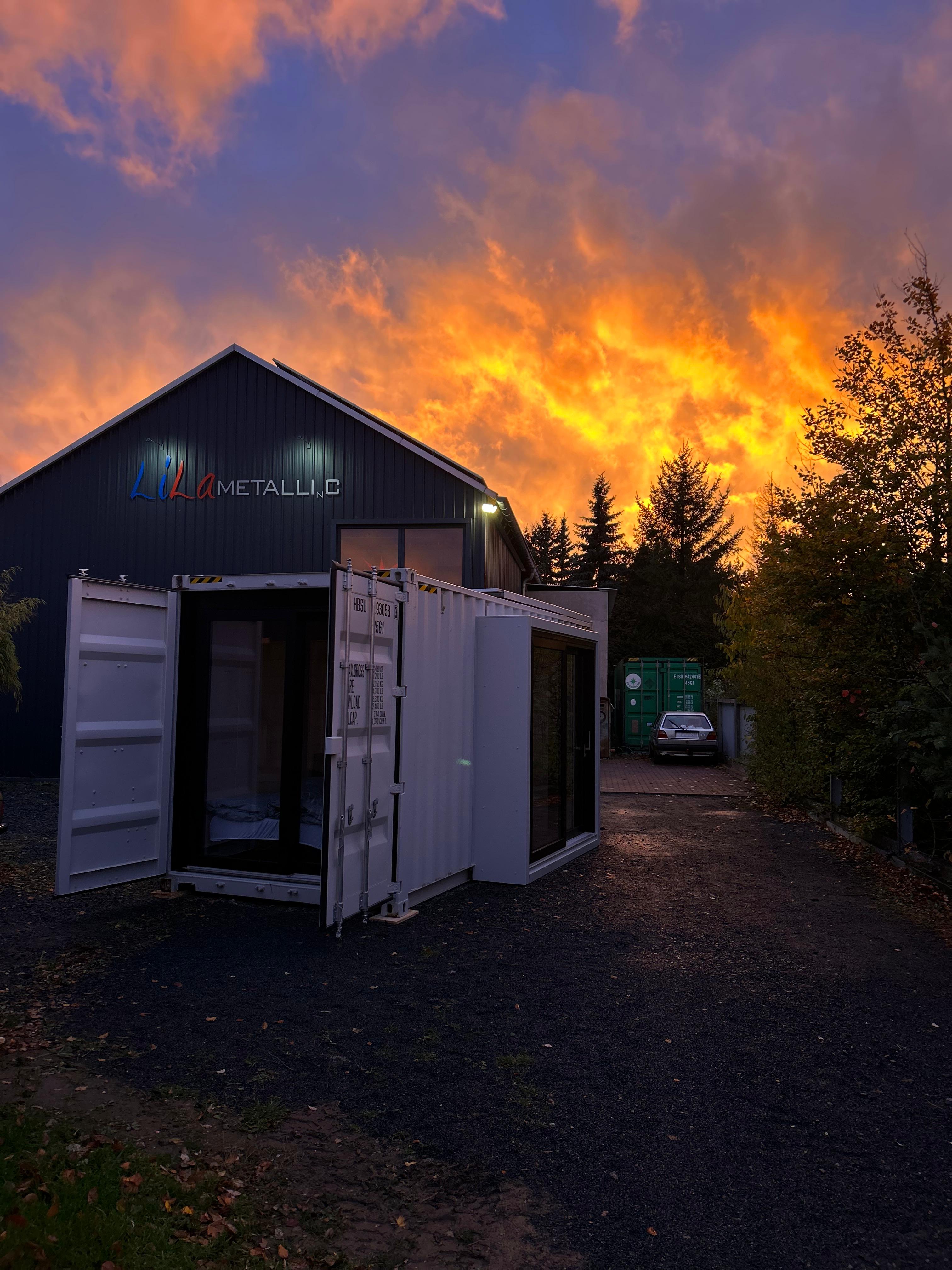 Monolith Container mit offener Seitentür bei Sonnenuntergang